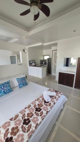 a bedroom with a large bed with a ceiling fan at ClubBoracay Apartelle in Boracay