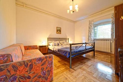 a bedroom with two beds and a couch in it at Apartment Mare Monti in Ičići