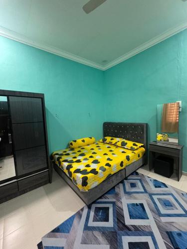 a bedroom with a bed with a yellow and black comforter at SYA Homestay Bachok in Bachok