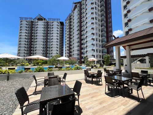 a patio with tables and chairs and buildings at Royal Oceancrest Eleanor suites in Lapu Lapu City