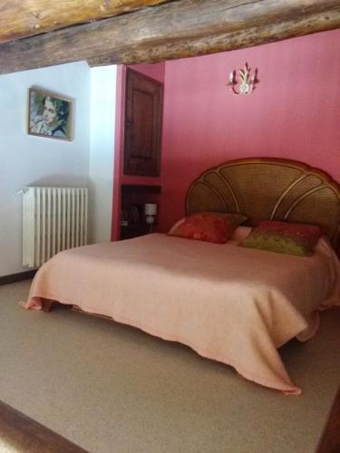 - une chambre avec un grand lit aux murs roses dans l'établissement La Grange, à Cruis