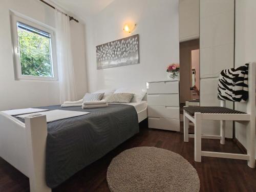 a small bedroom with a bed and a couch at Apartments Vuleta in Pag