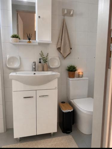 a white bathroom with a sink and a toilet at Villa Harmonia I -Elegant Retreat in Karlovasi