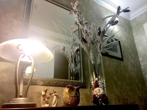 a lamp and a vase with flowers on a table at Evergreen Bed & Breakfast in Hope