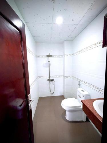 a white bathroom with a toilet and a sink at Yen Phu Hotel Tuy Hòa in Tuy Hoa