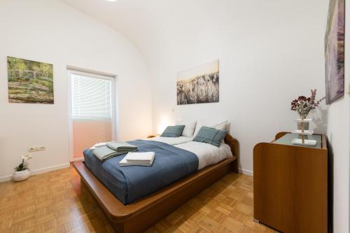 a bedroom with a large bed with blue pillows at Apartma Drapšinova - Celje in Celje