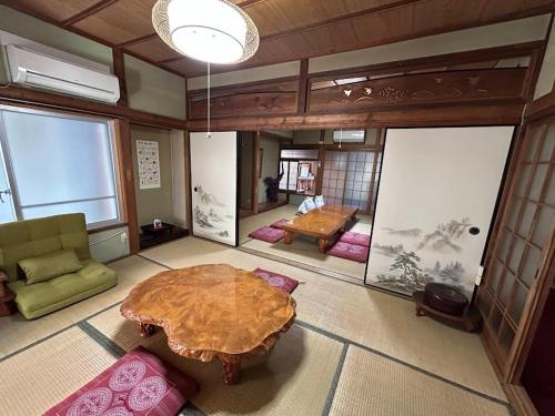 a living room with a table and a room with a couch at YADOease in Tsuiki