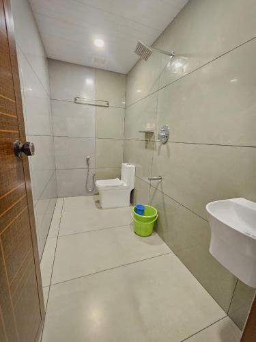 a bathroom with a shower and a toilet and a sink at Thekkady Nest Residency in Thekkady