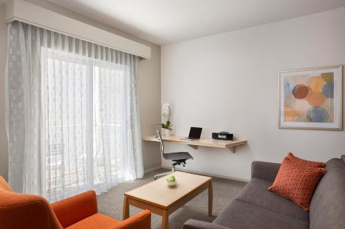 ein Wohnzimmer mit einem Sofa und einem Tisch in der Unterkunft Corporate Inn Sunnyvale - All-Suite Hotel in Sunnyvale