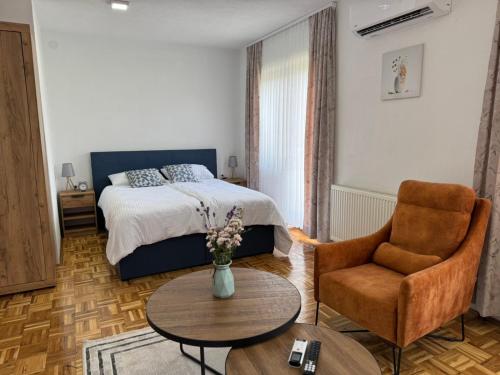 a bedroom with a bed and a table and a chair at Apartments & Spa - Insula Vita in Bihać