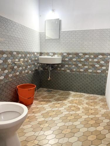 a bathroom with a toilet and a sink at Nariman's riverstone hevan Resort in Kelakam