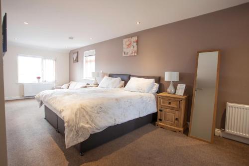 a bedroom with a large bed and a mirror at The White Swan Inn in Lowick