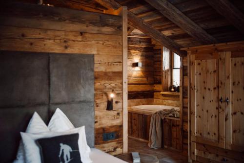 a bedroom with a bed and a bath tub at Chaletdorf Auszeit in Hüttschlag