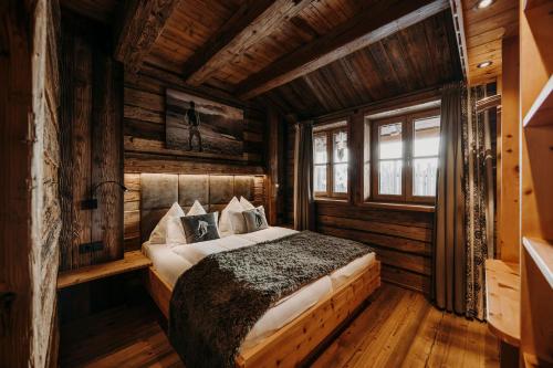 a bedroom with a bed in a log cabin at Chaletdorf Auszeit in Hüttschlag