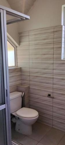 a bathroom with a toilet and a glass shower at Blue Water Resort in Diani Beach