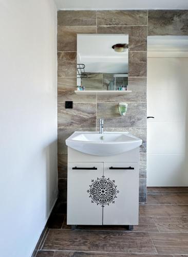 a bathroom with a white sink and a mirror at Arz'Urla Restaurant & Otel in Urla