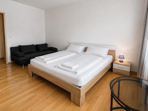 a bedroom with a large white bed and a couch at Ferien Wohnung in Chemnitz