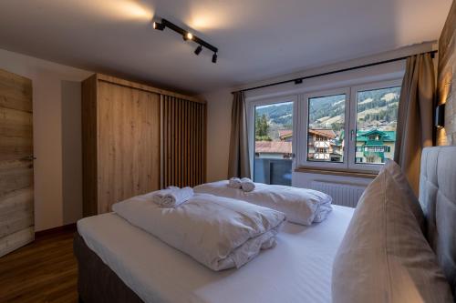 a bedroom with two beds and a large window at Alpen Lodge Kirchberg in Kirchberg in Tirol