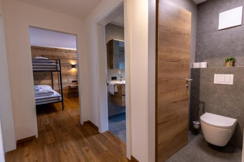 a bathroom with a toilet and a bed in a room at Alpen Lodge Kirchberg in Kirchberg in Tirol