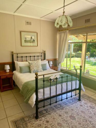 a bedroom with a bed and a large window at Warbler's Haven in Wakkerstroom