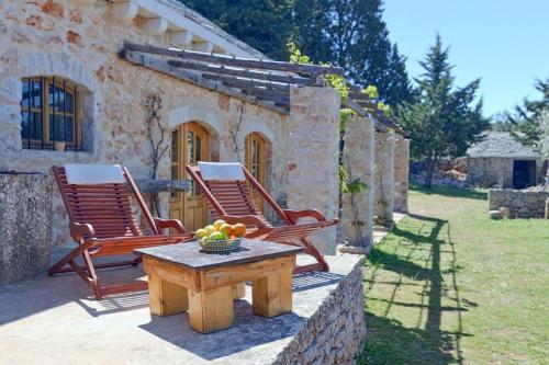 two chairs and a table in front of a house at Villa Humac Hvar in Poljica