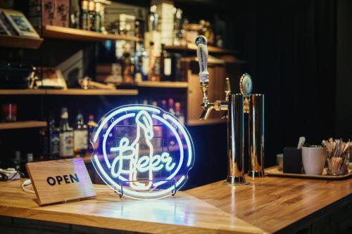 a neon sign sitting on top of a bar at GuestHouse Hostel MangeTak ゲストハウス マングタック広島 in Hiroshima