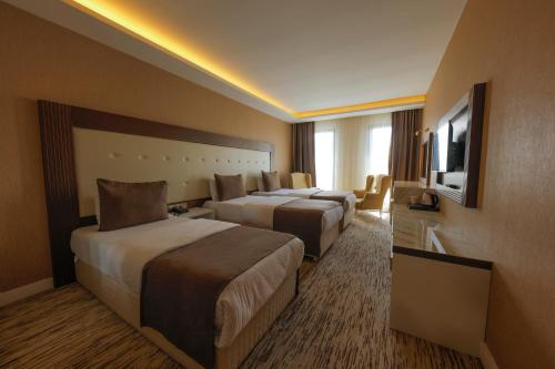a hotel room with two beds and a television at Vera Vista Hotel in Ipekyolu