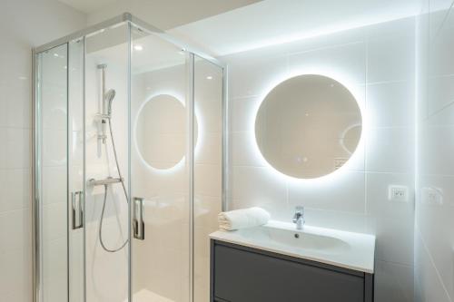 a white bathroom with a sink and a shower at Le Logis du Manoir in Sarzeau