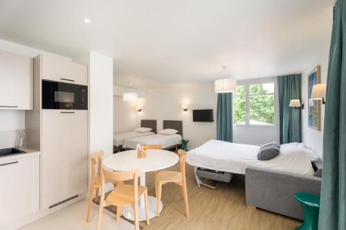 a small room with two beds and a table at Le Logis du Manoir in Sarzeau