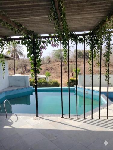 a house with a swimming pool with a pergola at Kevda Crown Estate in Keora