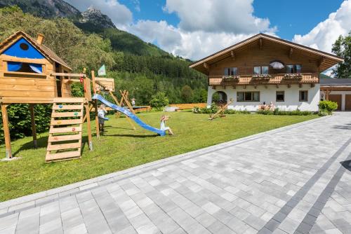 a backyard with a playground and a house at Haus Alpenblick Lofer in Lofer