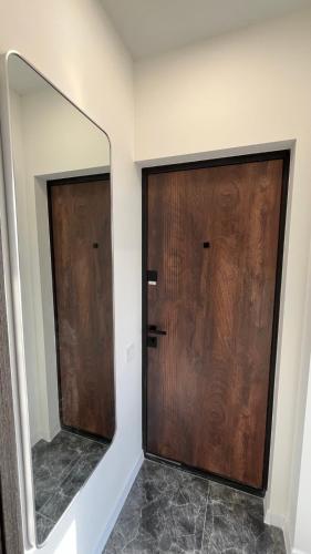 two wooden doors in a room with a mirror at ЖК АЯ Студія 1 плюс 1 in Kropyvnytskyi