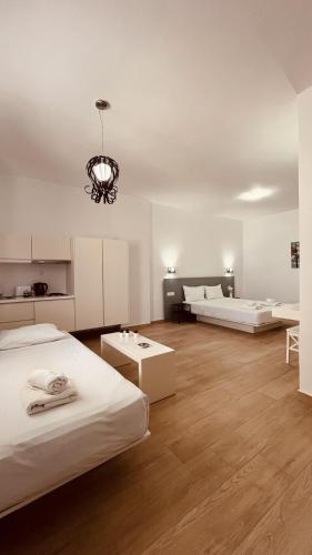 a large room with two beds and a chandelier at Aestas Apartments in Agia Marina Nea Kydonias