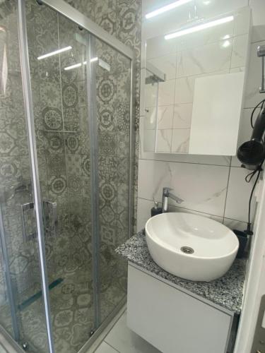 a bathroom with a sink and a glass shower at Bodrum Nuran Boutique Apart in Bodrum City