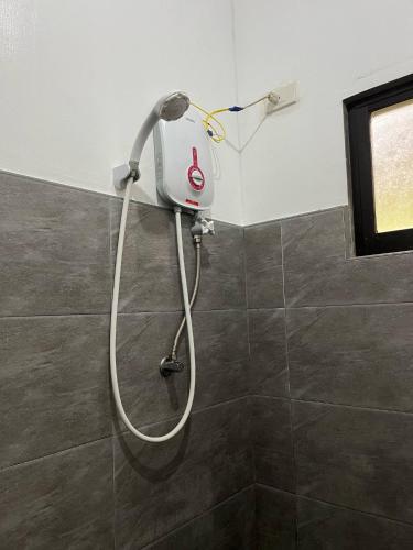 a shower in a bathroom with a shower head at Sapayag Backpacker's Inn in Dipolog