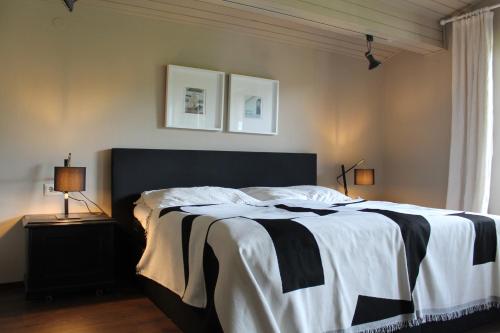 a bedroom with a bed with a black and white blanket at Dorfchalet in Goldegg