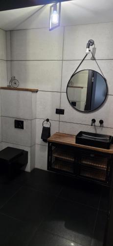 a bathroom with a sink and a mirror on a wall at Apartament z ogrodem Cyprysowy zakątek in Oświęcim