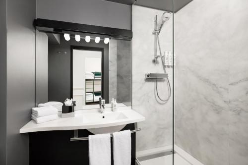 a bathroom with a sink and a shower at Moxy Paris La Villette in Paris