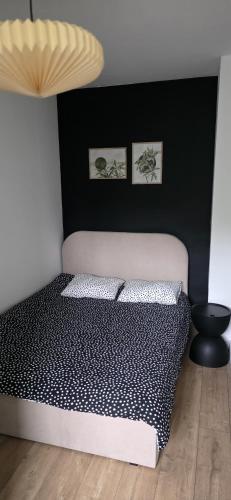 a bedroom with a bed with black and white sheets at Apartament z ogrodem Cyprysowy zakątek in Oświęcim