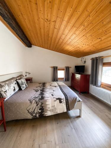 a bedroom with a bed and a wooden ceiling at Mansarda Ossana in Fucine