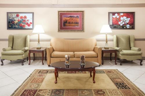 a living room with two chairs and a coffee table at Ramada by Wyndham Mountain Home in Mountain Home