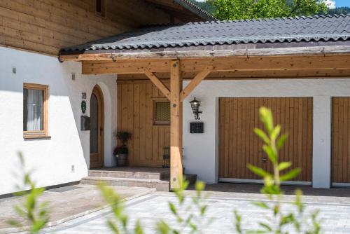 a wooden pergola on the side of a house at Haus Alpenblick Lofer in Lofer