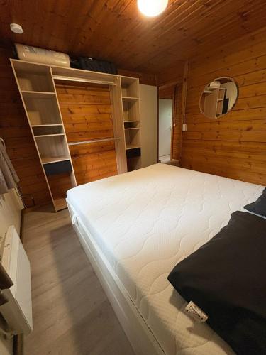 a bedroom with a bed in a wooden room at chalet 282 - La Boverie in Rendeux