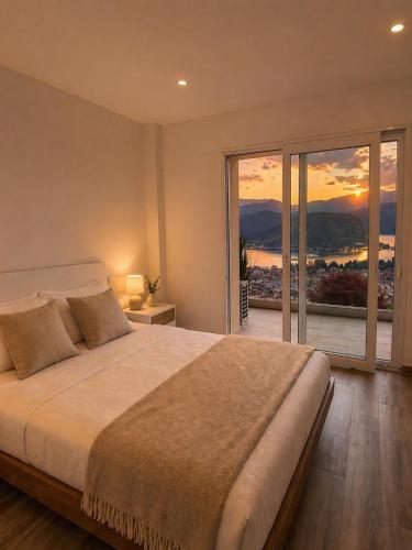a bedroom with a large bed and a large window at Lake View Apartament 39 - Free Parking & Terrace in Cadegliano Viconago