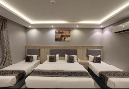 a room with three beds in a room at شقق ازار المخدومه in Medina