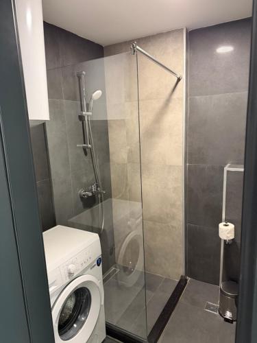 a bathroom with a washing machine and a shower at Batumi View Luxury in Adliye