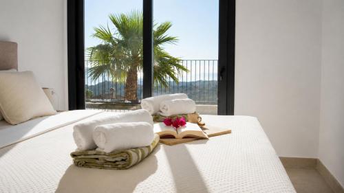 a bedroom with two beds with towels and a window at Villa Kala in Polop