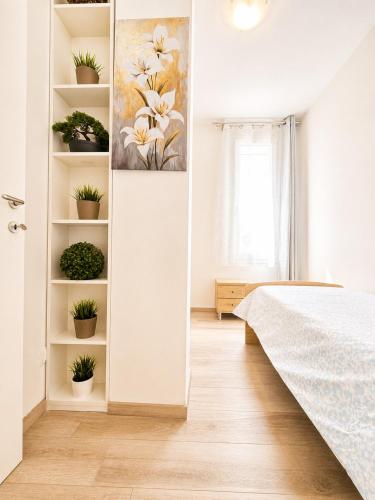 a bedroom with a painting of flowers on the wall at A due passi dal mare in Giulianova