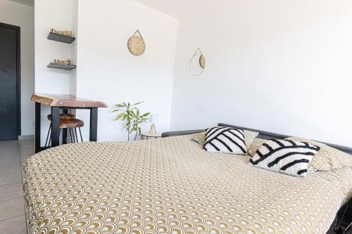 a bedroom with a bed with two pillows on it at "U Valincu" – Studio Centre Plage | by Efficios in Propriano