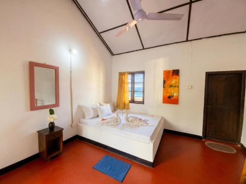 a bedroom with a bed and a ceiling fan at Bliss Bay Beach Resort & Spa in Nilaveli